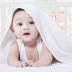 タオルケットをかぶる赤ん坊